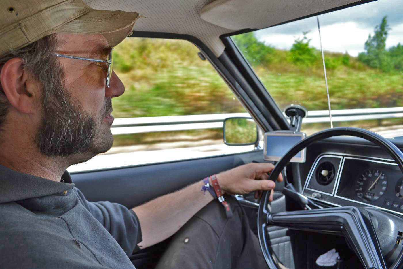 Mann drückt knopf am zündschlüssel mit wegfahrsperre auf dem hintergrund  des autos